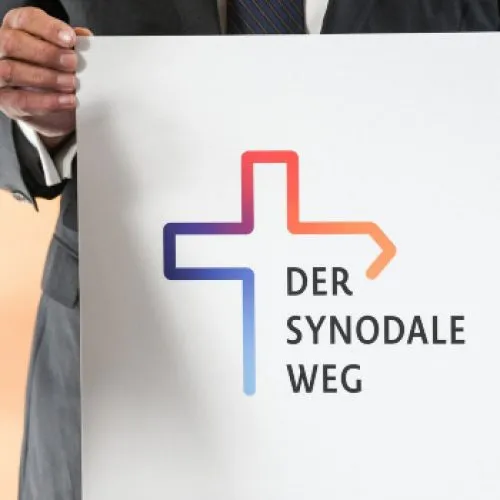 Hände halten ein Schild mit dem Logo zum geplanten Dialog zur Zukunft der katholischen Kirche in Deutschland am 8. November 2019 in Bonn.